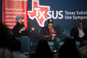 TxSUS Substance Use Symposium event with presenters on stage